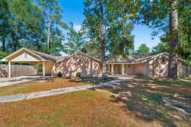 a view of a house with a yard and large tree