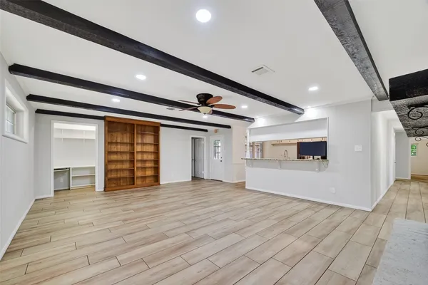 a view of empty room with wooden floor and windows