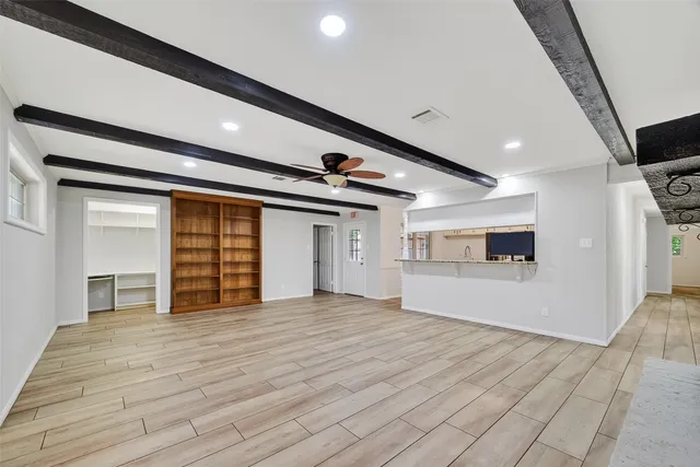a view of empty room with wooden floor and windows