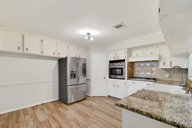 a kitchen with granite countertop a refrigerator and a sink