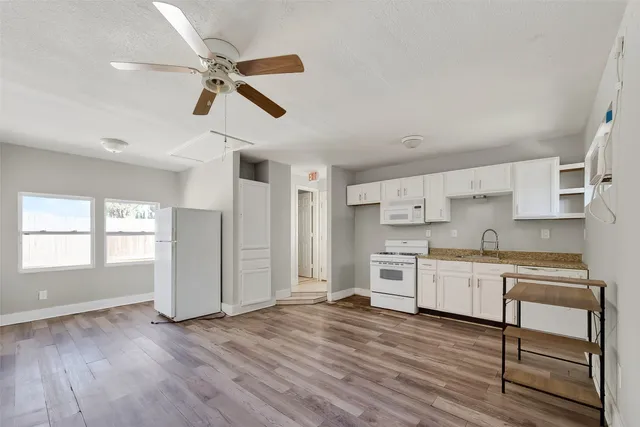 a large kitchen with cabinets wooden floor and stainless steel appliances
