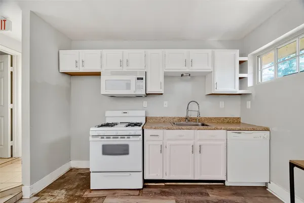 a white kitchen with white cabinets and white appliances