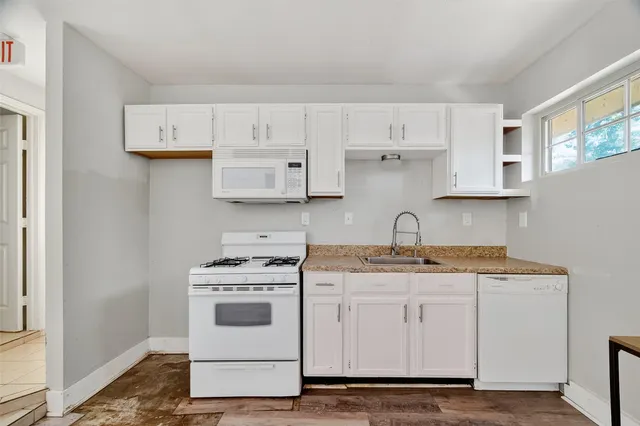 a white kitchen with white cabinets and white appliances