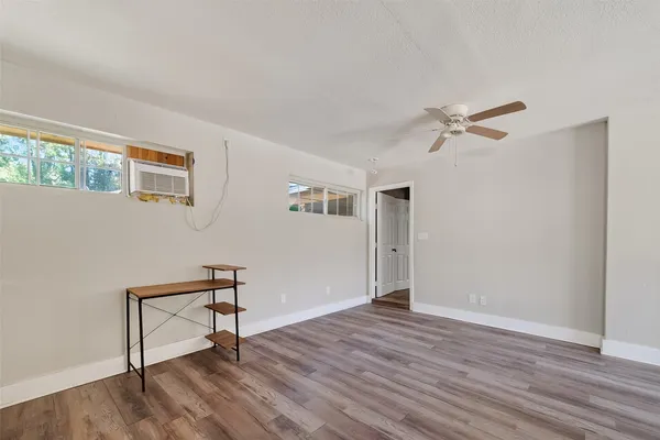 a view of room with hardwood floor and a ceiling fan