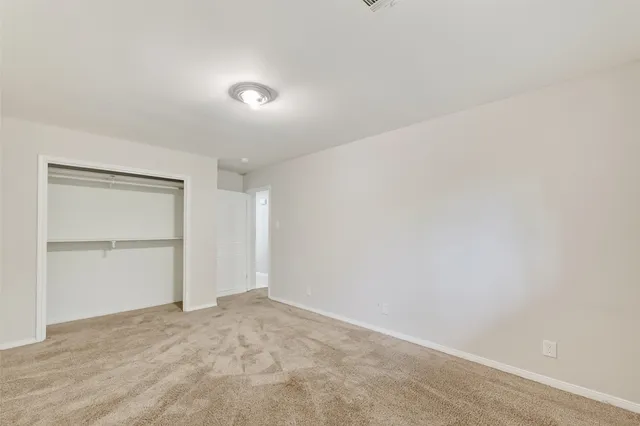 an empty room with closet and windows