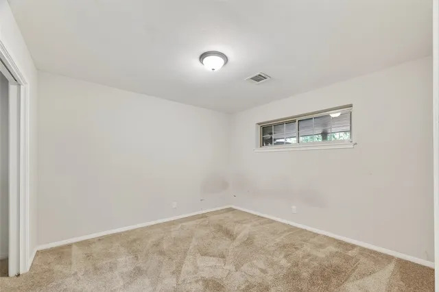 an empty room with closet and windows