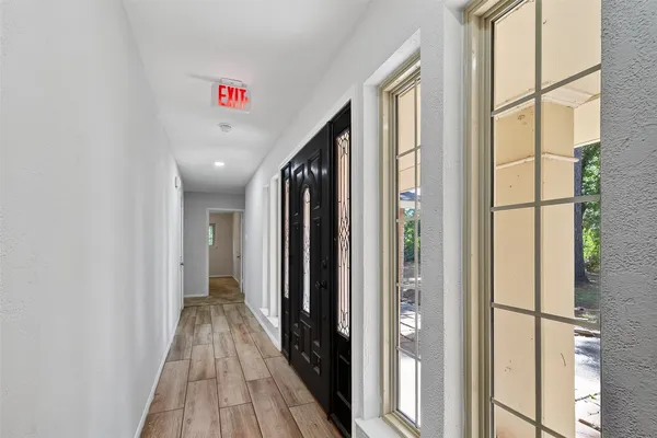 a view of a hallway with wooden floor and entryway