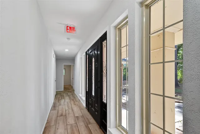 a view of a hallway with wooden floor and entryway