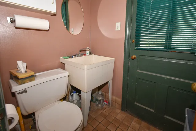 a bathroom with a toilet a sink and a mirror