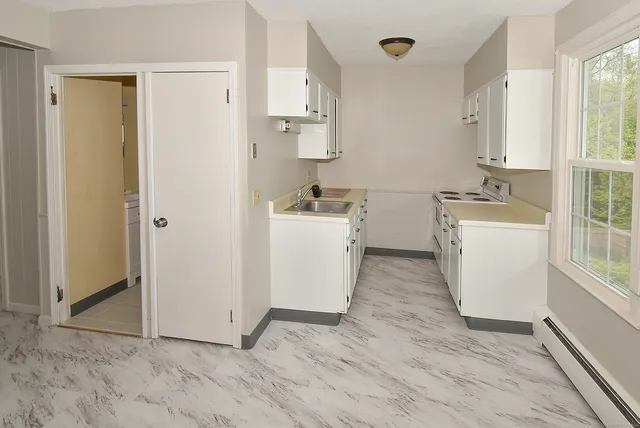 a view of a kitchen with sink and refrigerator