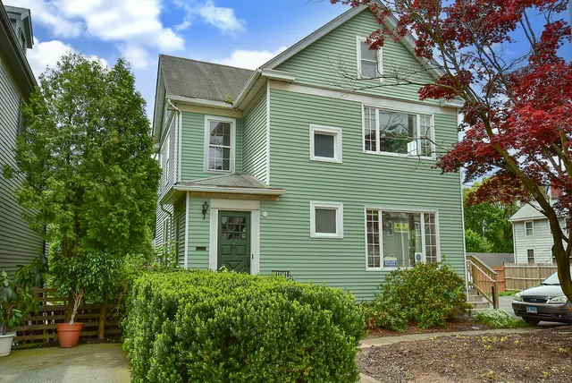 a view of a house with a yard and potted plants