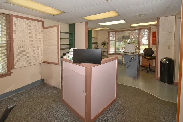 a view of a livingroom with workspace and a window
