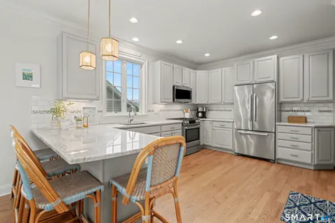 a kitchen with granite countertop a refrigerator stove microwave and cabinets