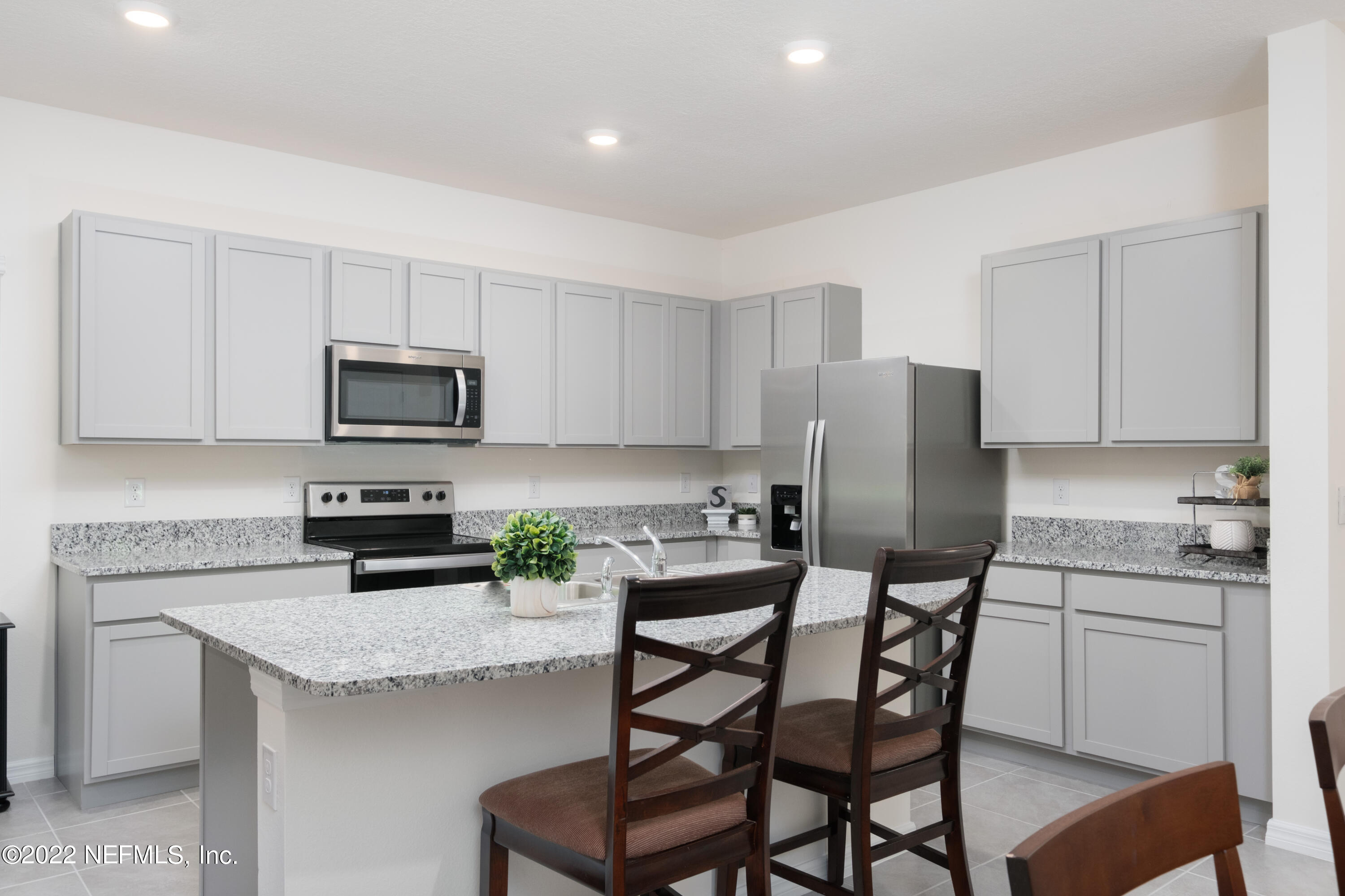 13803 Northwest 9th Road Newberry, FL 32669 - Photo 5 of 21 a kitchen with a table chairs microwave and refrigerator