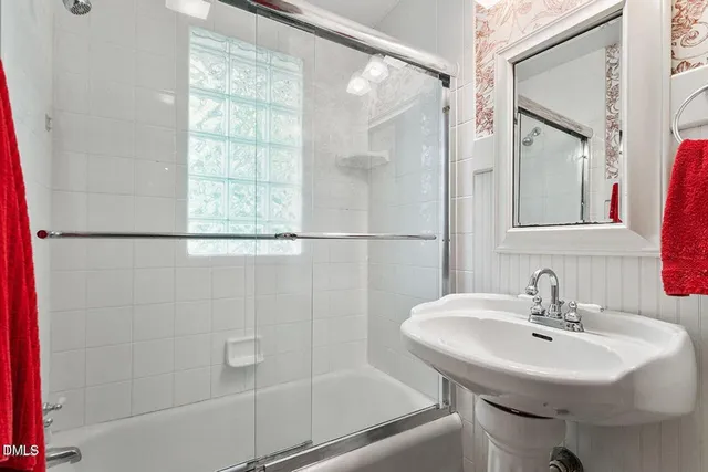 a bathroom with a sink shower and a mirror