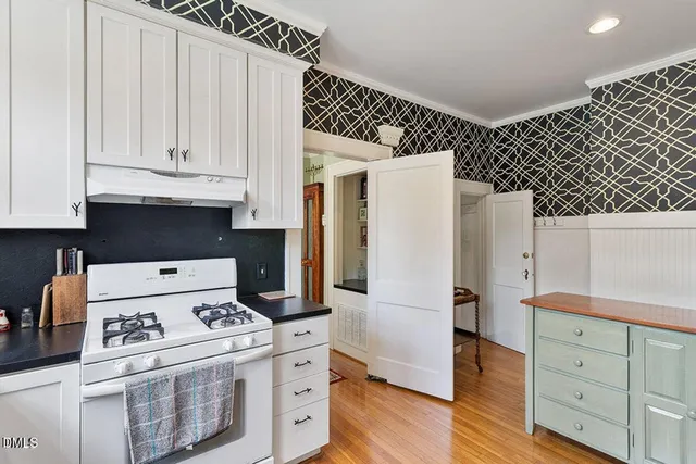 a kitchen with a stove and white cabinets
