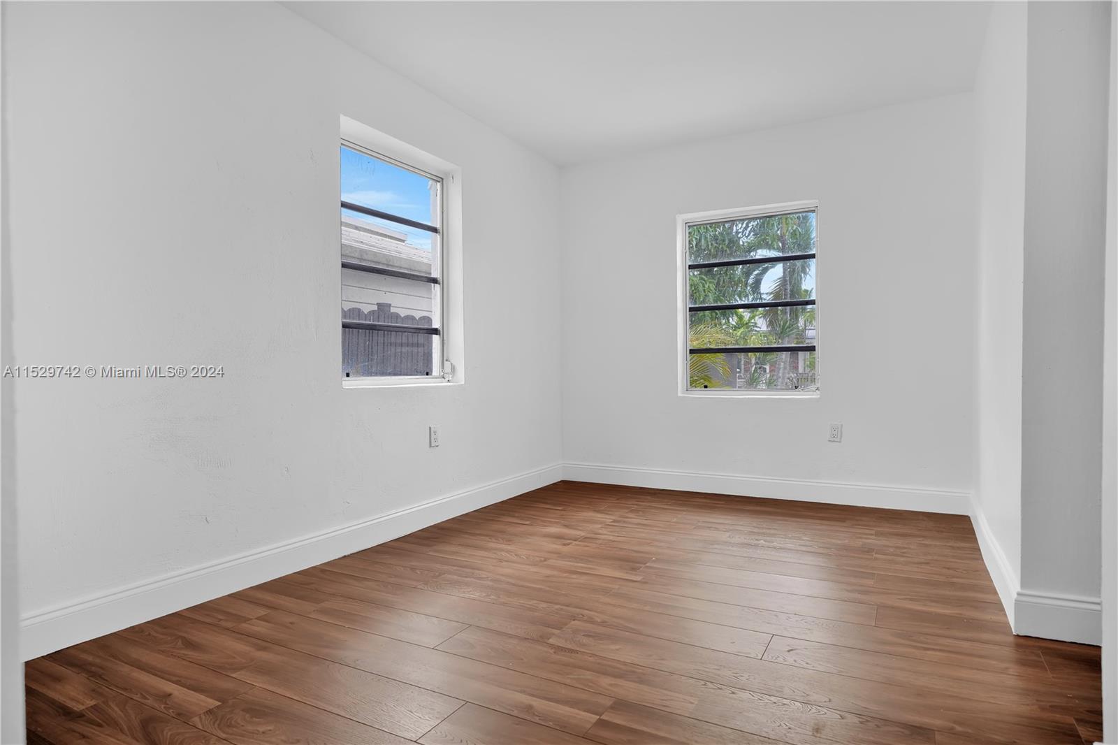 1886 Southwest 16th Terrace Miami, FL 33145 - Photo 11 of 14 an empty room with wooden floor and windows