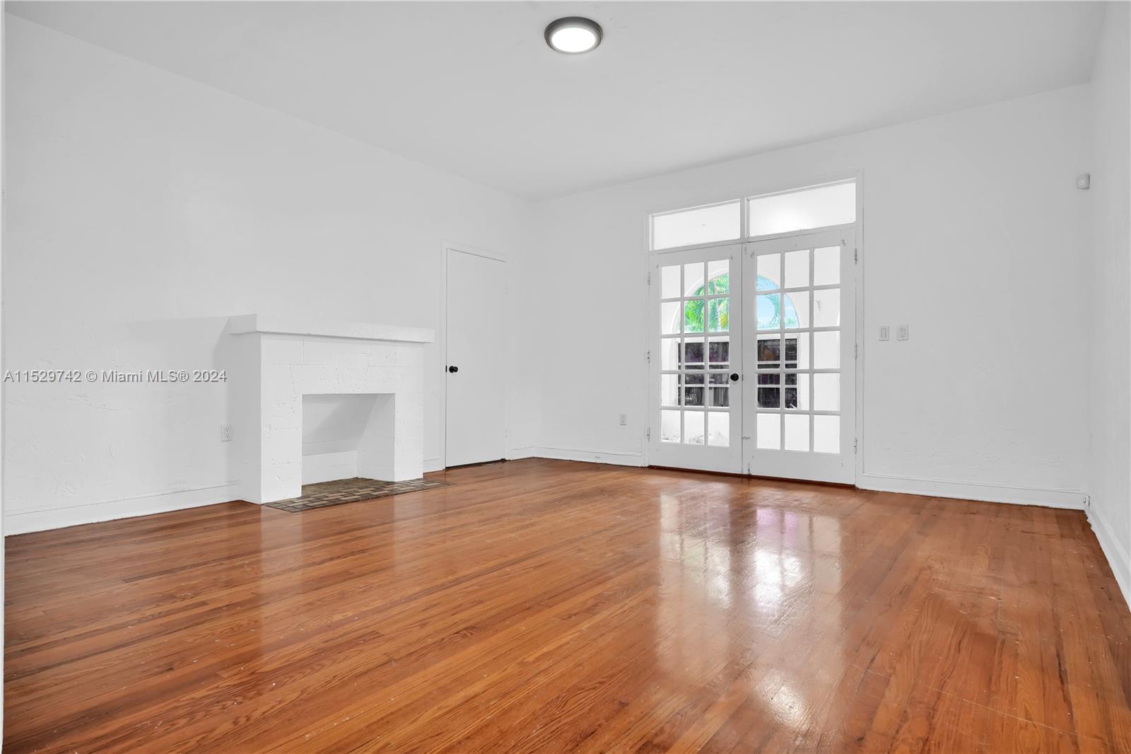 1886 Southwest 16th Terrace Miami, FL 33145 - Photo 4 of 14 a view of an empty room with wooden floor and a window