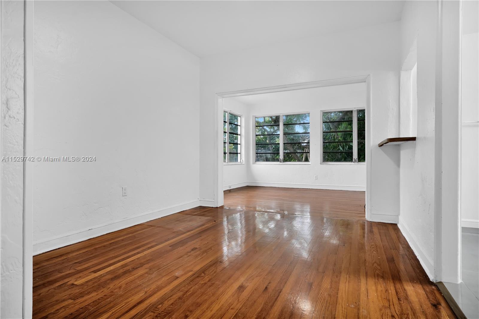 1886 Southwest 16th Terrace Miami, FL 33145 - Photo 5 of 14 a view of an empty room with wooden floor and a window