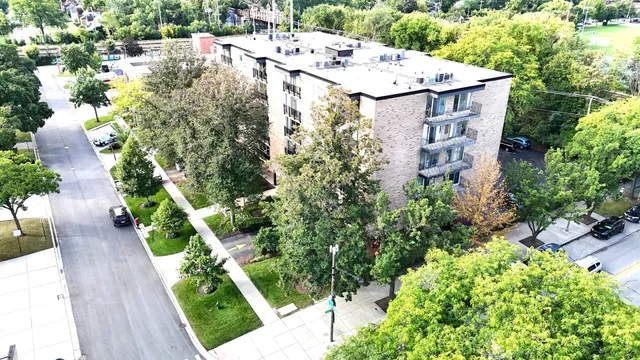 an aerial view of residential house with outdoor space and trees all around