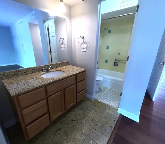 a bathroom with a granite countertop sink a mirror and a vanity