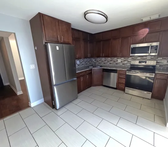 a kitchen with stainless steel appliances granite countertop a refrigerator stove and sink
