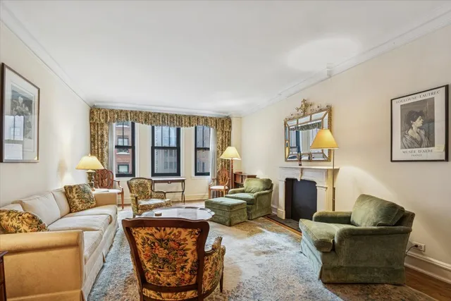 a living room with furniture a large window and a table