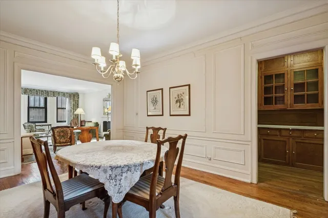 a dining room with furniture a chandelier and wooden floor