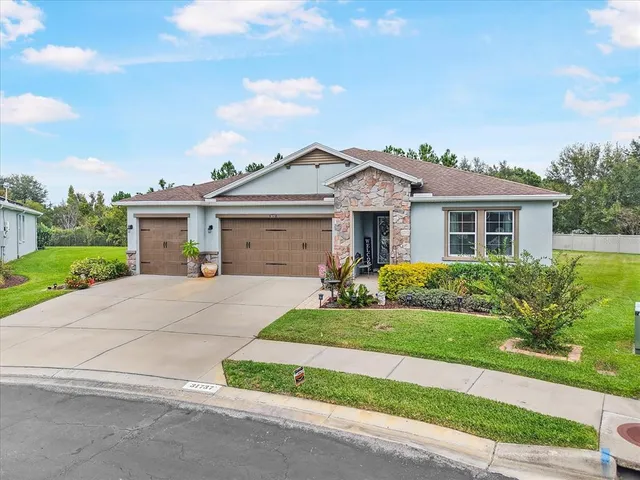 a front view of a house with a garden and yard