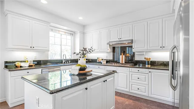 a kitchen with granite countertop white cabinets and white appliances