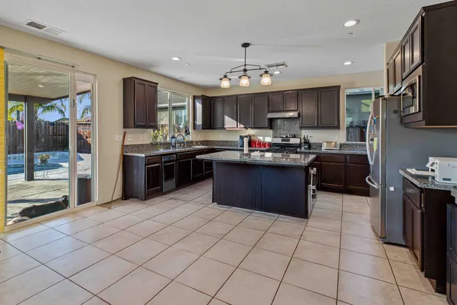 a kitchen with stainless steel appliances granite countertop a sink counter space cabinets and a stove