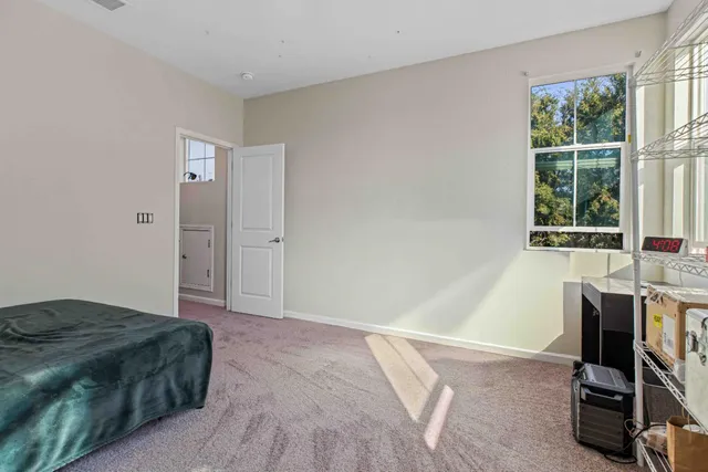 a bedroom with a bed a table and windows