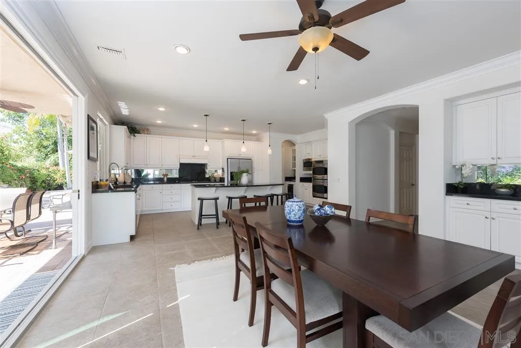 11692 Eastfield Road Poway, CA 92064 - Photo 6 of 25 a kitchen with a dining table chairs and white appliances