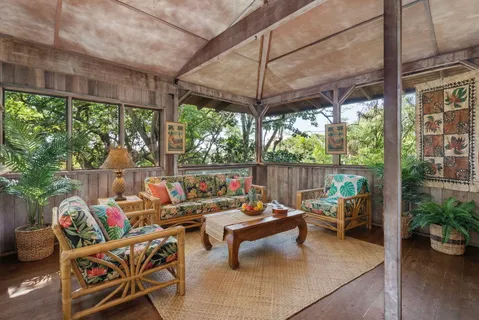 a living room with patio furniture and a potted plant