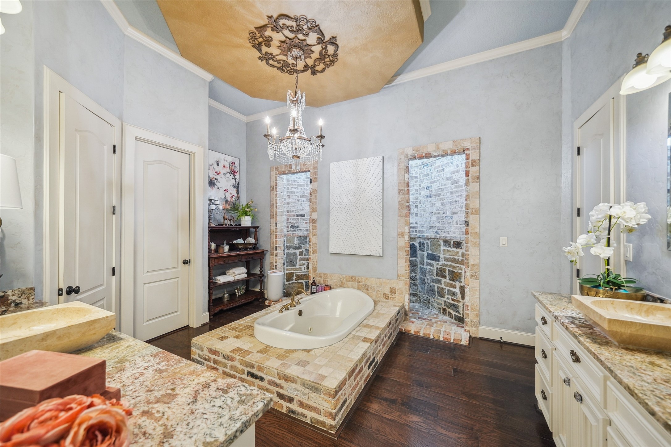 460 Bishop Road Huntsville, TX 77320 - Photo 18 of 50 The luxurious bathroom offers dual vanities with granite countertops and travertine sinks. A stunning chandelier hangs above the jacuzzi tub, creating a spa-like ambiance.