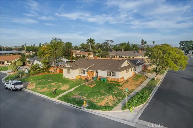 an aerial view of residential houses with outdoor space and trees
