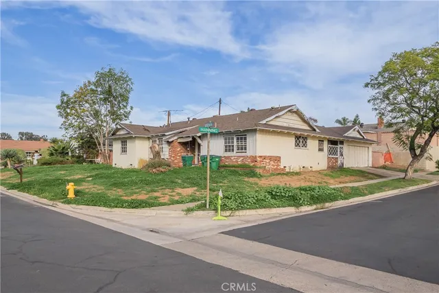 a view of a white house next to a yard and road