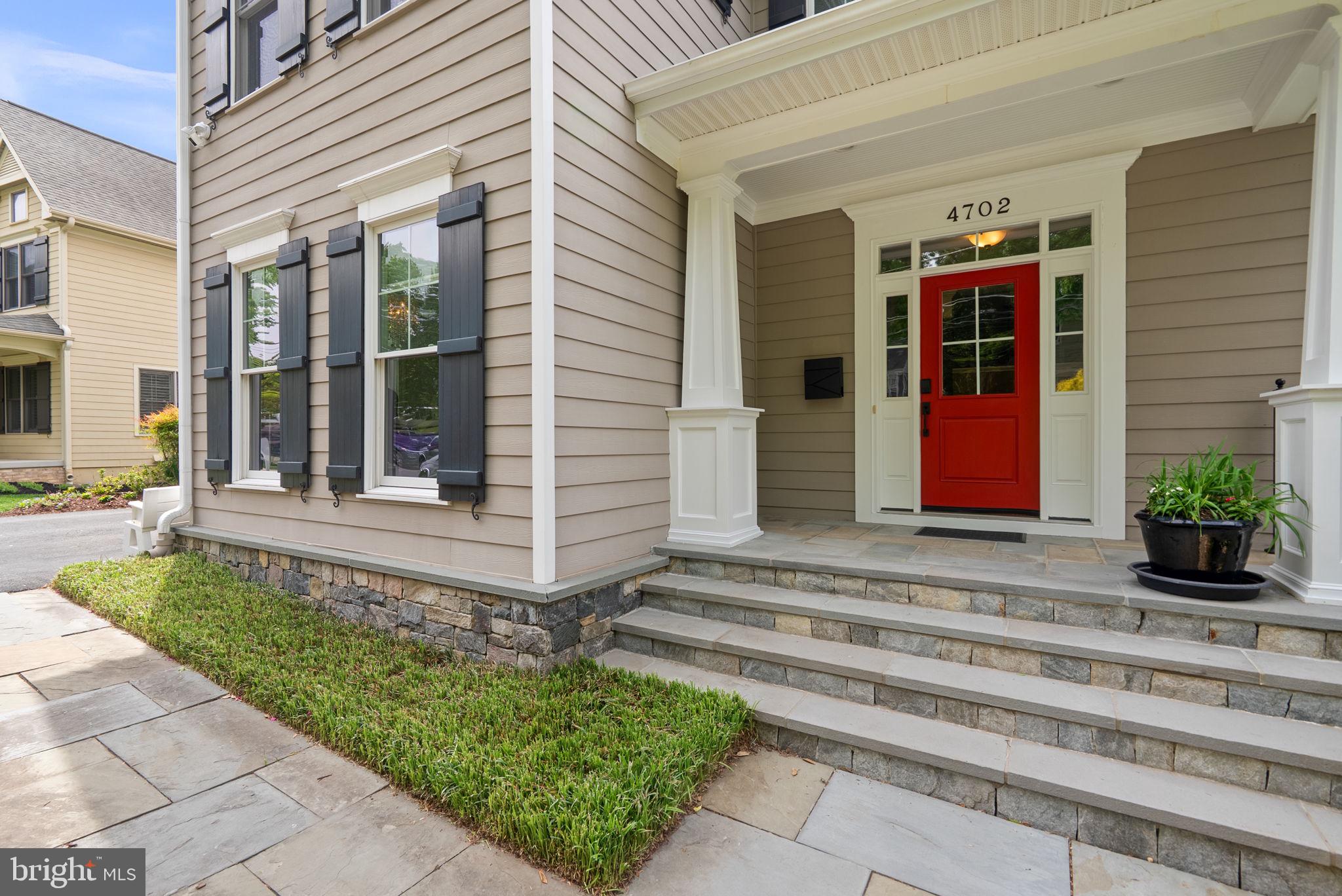 Charming entrance with vibrant red door.