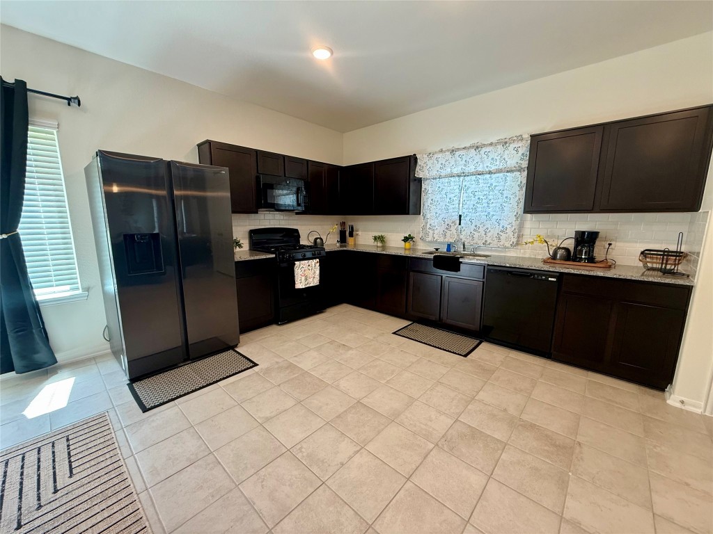 527 Baobab Way Crosby, TX 77532 - Photo 10 of 50 a kitchen with stainless steel appliances a refrigerator sink and microwave