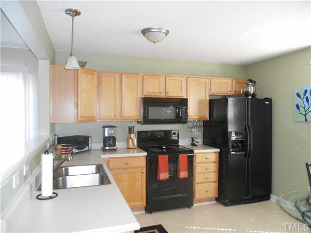 5012 Mocha Lane Raleigh, NC 27616 - Photo 4 of 14 a kitchen with stainless steel appliances granite countertop a refrigerator a stove and a sink with wooden floor