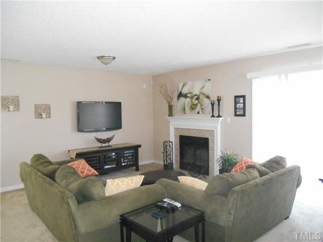 5012 Mocha Lane Raleigh, NC 27616 - Photo 5 of 14 a living room with furniture a flat screen tv and a fireplace
