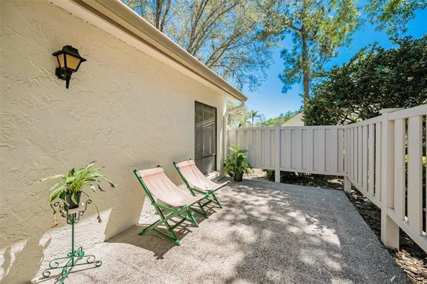 a view of a backyard with wooden fence and a large tree