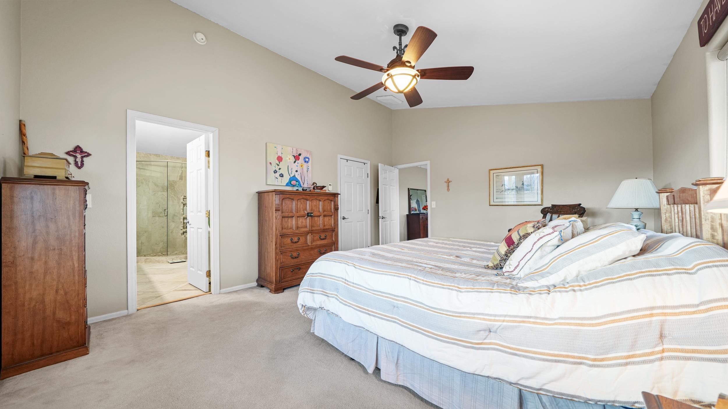1392 M M 1/4 Road Loma, CO 81524 - Photo 15 of 42 a spacious bedroom with a bed and a chandelier