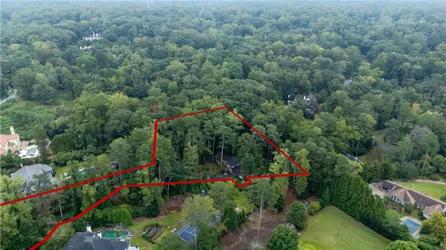 an aerial view of residential houses with outdoor space and trees