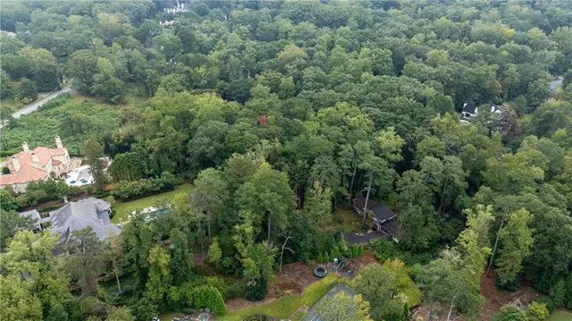 an aerial view of residential house with outdoor space and trees all around