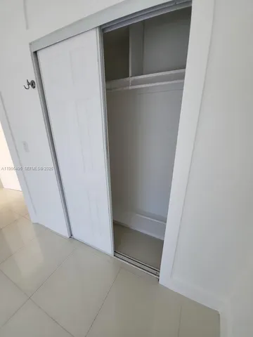 a view of an empty room with a fireplace and a window