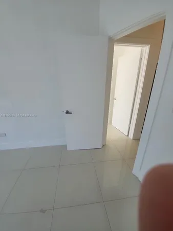 a view of hallway with window and a ceiling fan