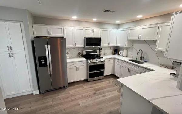 a kitchen with white cabinets and stainless steel appliances