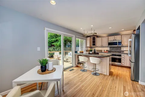 a kitchen with a sink appliances cabinets and wooden floor