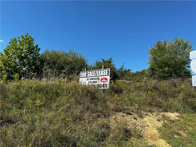 a view of a sign board with large trees